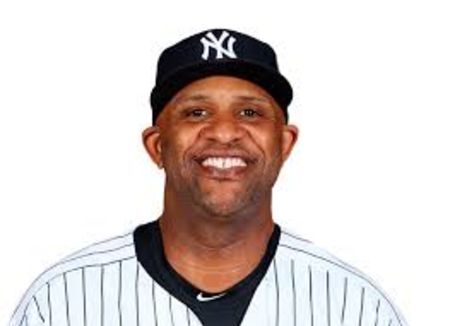 CC Sabathia in a white jersey poses for  a picture.